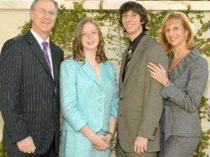 Smiling family of four in formal suits
