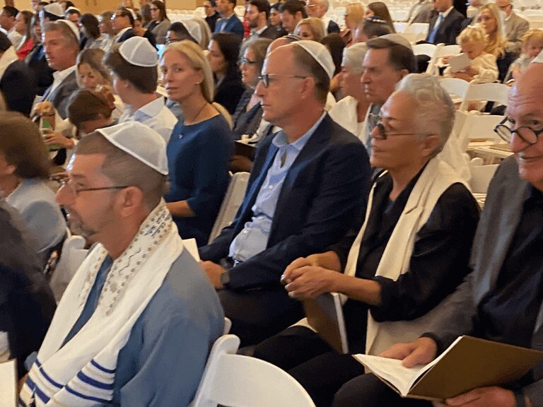 A group of people sitting in chairs wearing white hats.