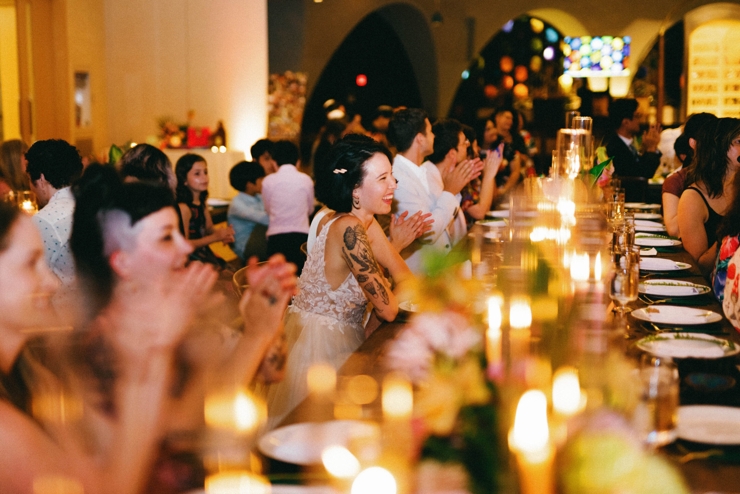 A group of people sitting at tables with candles.