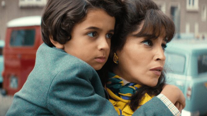 Woman holding child, looking concerned outdoors.