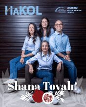 Four people smiling together with festive greeting.